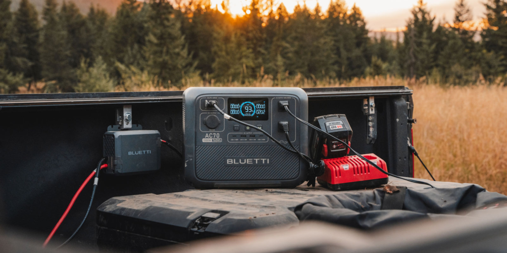BLUETTI Charger 1 beside a connected AC70 power station in a pickup truck